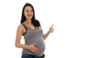 futura mãe grávida feliz mostrando os polegares para cima e sorrindo isolado no fundo branco foto