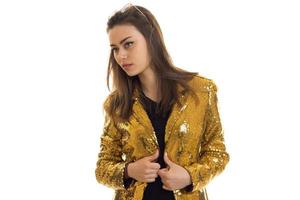mulher fashionbale em jaqueta dourada olha de lado foto