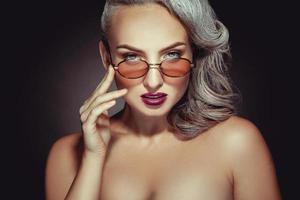 mulher elegante com cor de cabelo grisalho e bela maquiagem em óculos de sol foto