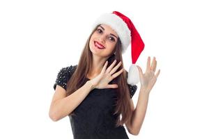 alegre menina morena com chapéu de Papai Noel foto