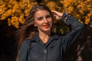 linda jovem com batom vermelho nos lábios e camisa preta no parque foto