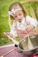 adorável menina jogando chef de cozinha foto