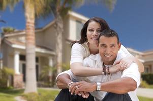 casal jovem hispânico feliz na frente de sua nova casa foto