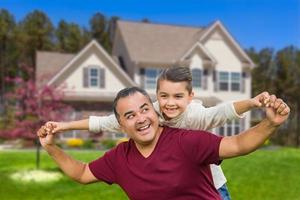 pai hispânico e filho mestiço se divertindo na frente de casa foto