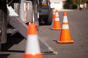 cones de perigo laranja e caminhão utilitário na rua foto