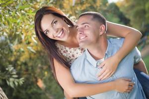 retrato de casal romântico de raça mista no parque foto