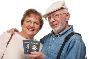 feliz casal sênior com passaportes e malas em branco foto