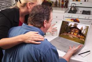 casal na cozinha usando laptop - cabine foto