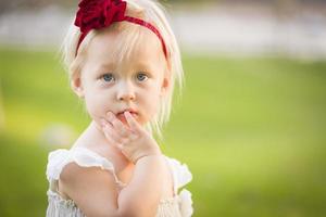 adorável menina usando vestido branco em um campo de grama foto