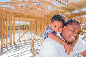 jovem pai afro-americano e filho mestiço no local dentro de sua nova estrutura de construção de casa. foto