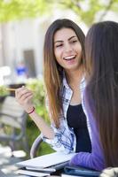 mulher jovem e expressiva de raça mista sentada e conversando com a namorada foto