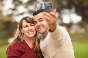 casal atraente de raça mista tirando autorretratos foto