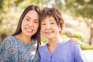 retrato ao ar livre de uma feliz mãe chinesa e filha foto