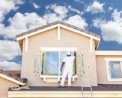 pintor de casa profissional pintando a guarnição e persianas de uma casa. foto