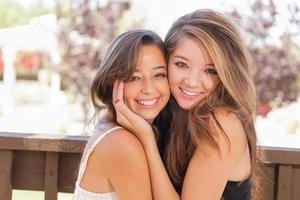 duas namoradas mestiças posam para retrato ao ar livre foto