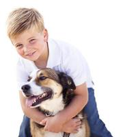 menino bonito brincando com seu cachorro isolado foto