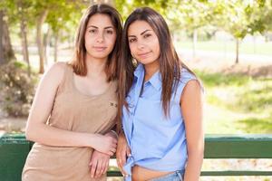 retrato de duas lindas irmãs gêmeas étnicas ao ar livre. foto