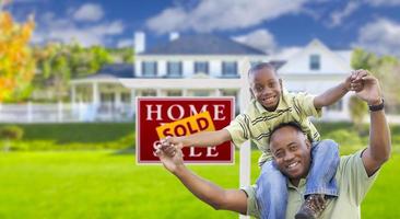 pai e filho na frente do sinal imobiliário e casa foto