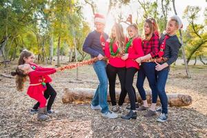 retrato de família de raça mista com crianças amarrando grupo com corda de ouropel foto