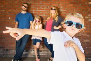 bonito jovem caucasiano usando óculos escuros com a família por trás foto