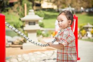 jovem menino chinês e caucasiano se divertindo no parque. foto