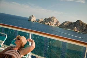 linda mulher relaxa no convés de um navio de cruzeiro foto