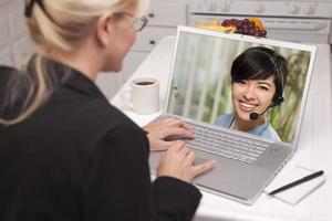 mulher na cozinha usando laptop - online com enfermeira ou médico foto