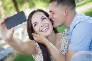 casal de raça mista tirando autorretrato no parque foto