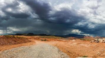 sinistro céu tempestuoso e nuvens cumulus com chuva no deserto foto