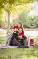 família de raça mista desfrutando de presentes de natal no parque juntos foto