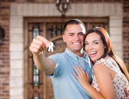 jovem casal militar na frente da porta da casa nova segurando as chaves foto