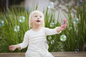 adorável menina se divertindo com bolhas foto