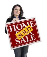 mulher hispânica segurando casa vendida para venda sinal em branco foto