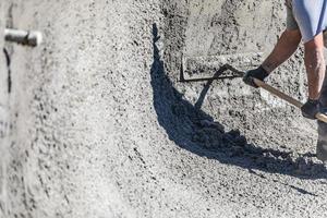 trabalhador da construção civil piscina trabalhando com um boia em concreto molhado foto