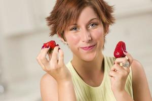 linda mulher ruiva comendo morango foto