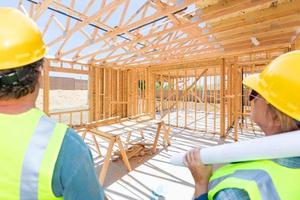 empreiteiros masculinos e femininos com vista para o enquadramento da nova casa no canteiro de obras foto