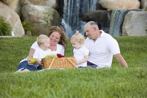 família jovem feliz gosta de piquenique no parque foto