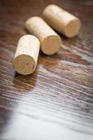 rolhas de vinho em branco descansando na superfície de madeira reflexiva. foto
