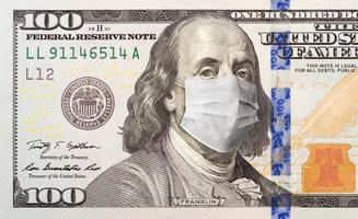nota de cem dólares com máscara facial médica no rosto de benjamin franklin foto