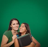 quadro de giz em branco atrás de uma orgulhosa mãe hispânica e uma filha estudante foto