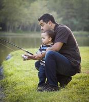 feliz jovem étnico pai e filho pescando foto