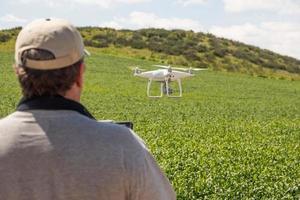 piloto de drone uav voando e coletando dados sobre terras agrícolas do país foto