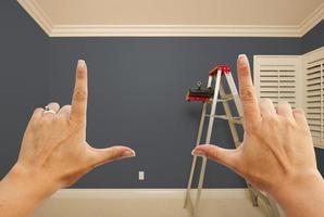 mãos emoldurando o interior da parede pintada de cinza foto