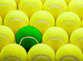 grupo de bolas de tênis amarelas e uma verde foto