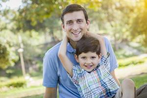 belo retrato de parque de pai e filho de raça mista foto