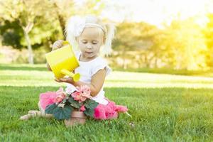 menina bonitinha jogando jardineiro com suas ferramentas e vaso de flores. foto