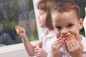 irmã e irmão comendo uma maçã foto