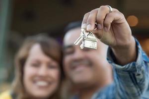 casal de raça mista segurando novas chaves de casa foto