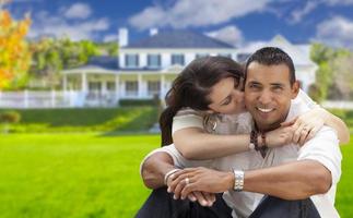 casal jovem hispânico feliz na frente de sua nova casa foto