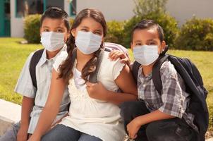 jovens estudantes hispânicos no campus da escola usando máscaras médicas foto